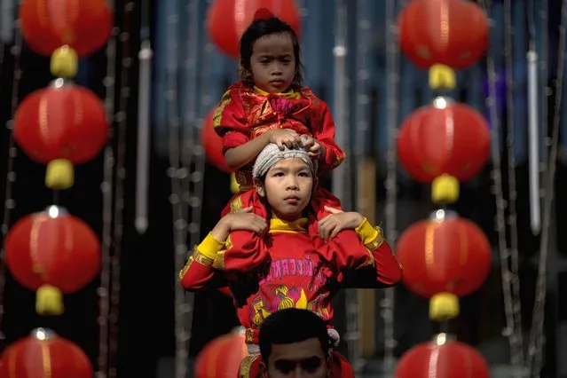 Young acrobats form a human tower during a performance on the eve of lunar new year in the Chinatown area of Bangkok on January 21, 2023. (Photo by Jack Taylor/AFP Photo)