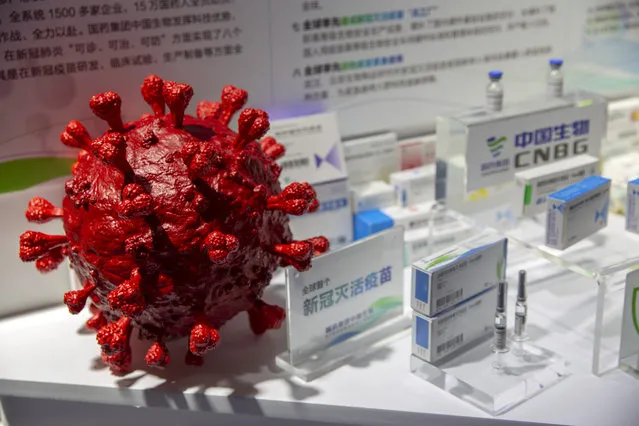 A model of a coronavirus is displayed next to boxes for COVID-19 vaccines at an exhibit by Chinese pharmaceutical firm Sinopharm at the China International Fair for Trade in Services (CIFTIS) in Beijing, Saturday, September 5, 2020. China said Friday, October 9, 2020, that it is joining the COVID-19 vaccine alliance known as COVAX. (Photo by Mark Schiefelbein/AP Photo)