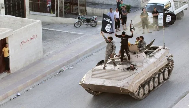 Militant Islamist fighters take part in a military parade along the streets of northern Raqqa province, in this June 30, 2014 file photo. (Photo by Reuters/Stringer)