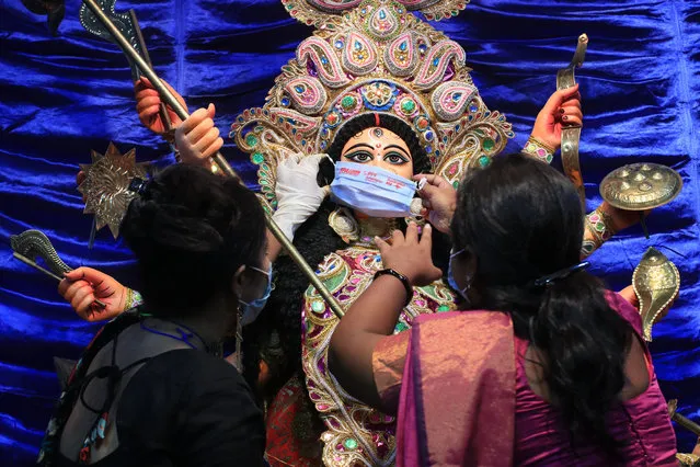 A mask is put on a statue of the Hindu goddess Durga to spread awareness of Covid-19 at the start of the five-day Durga Puja festival in Kolkata, India on October 22, 2020. (Photo by Dipa Chakraborty/Pacific Press/Rex Features/Shutterstock)