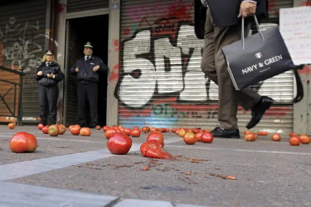 A man walks past tomatos that students threw against the entrance of Labour Ministry during a students protest in Athens, Greece, 05 November 2015. Students oppose austerity measures in education sector. (Photo by Orestis Panagiotou/EPA)