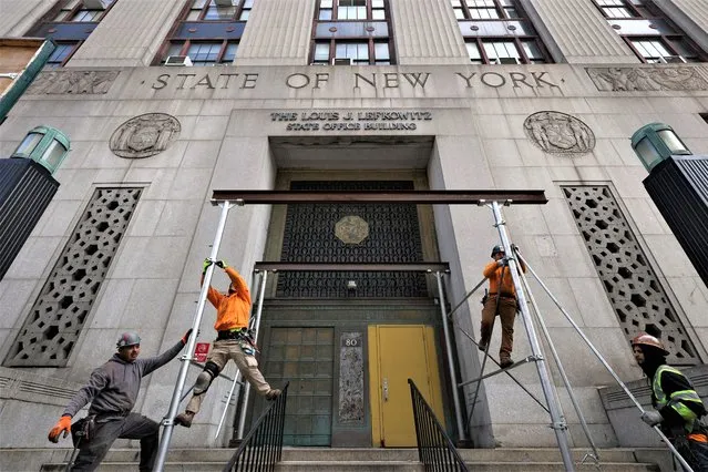 Workers remove scaffolding at the New York Courthouse at 80 Centre Street where Manhattan District Attorney Alvin Bragg continues his investigation into former U.S. President Donald Trump, in Manhattan, New York City, U.S., March 18, 2023. (Photo by Andrew Kelly/Reuters)