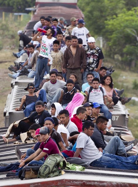 Migrants ride on top of a northern bound train toward the US-Mexico border in Juchitan, southern Mexico, Monday, April 29, 2013. Migrants crossing Mexico to get to the U.S. have increasingly become targets of criminal gangs who kidnap them to obtain ransom money. (Photo by Eduardo Verdugo/AP Photo)