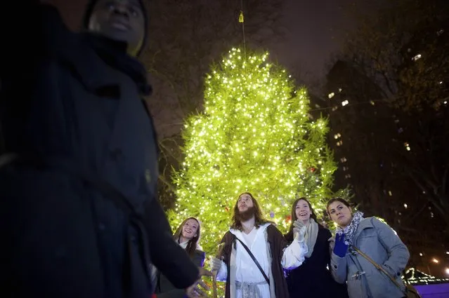 (L-R) Emily Harton, Shana Harton, and Paige Heenan ask to take a photo with Michael Grant, 28, “Philly Jesus”, (center) at Rittenhouse Square in Philadelphia, Pennsylvania December 14, 2014. (Photo by Mark Makela/Reuters)