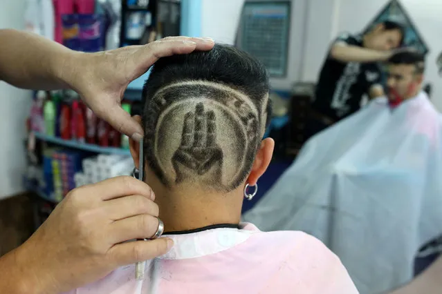 Mitree Chitinunda, a former ultra-royalist who once got a haircut of King Maha Vajiralongkorn's portrait on the back of his head with words “Long Live the King” last year, changes his haircut after the protests emerged, to the three-fingers salute, a symbol of anti-government protest that is demanding curb for monarchy's power in Bangkok, Thailand on November 24, 2020. (Photo by Soe Zeya Tun/Reuters)