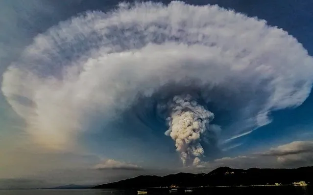 A plume of ash erupts from the Taal volcano in the Philippines on January 13, 2020. Situated on an island in the middle of a lake, it is one of the world's smallest volcanoes and has recorded at least 34 eruptions in the past 450 years. (Photo by Kenji Cheow/Magnus News)