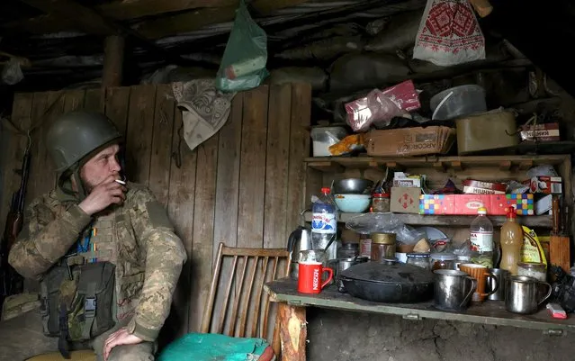 Ukrainian service man Yuzik (43) of the 24th brigade smokes a cigarette at his shelter in the trenches at the frontline, amid Russia?s attack on Ukraine near Niu York, Donetsk region, Ukraine on April 4, 2023. (Photo by Kai Pfaffenbach/Reuters)