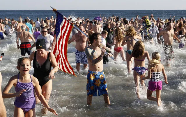 People run in and out of the cold Atlantic Ocean during the Sons of Ireland's annual New Year's Day Polar Bear Plunge on a sunny, but frigid Thursday, January 1, 2015, in Asbury Park, N.J. (Photo by Mel Evans/AP Photo)