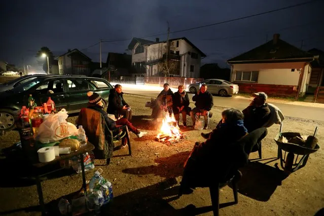 People warm up around a fire after an earthquake, in Petrinja, Croatia on December 29, 2020. (Photo by Antonio Bronic/Reuters)