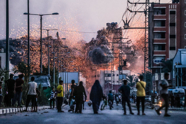 Palestinians stand on a road as black smoke and flames rise over a building after Israeli attacks in Deir al-Balah, Gaza, on 6 June 2024. (Photo by Ali Jadallah/Anadolu Agency/Siena awards festival 2025)