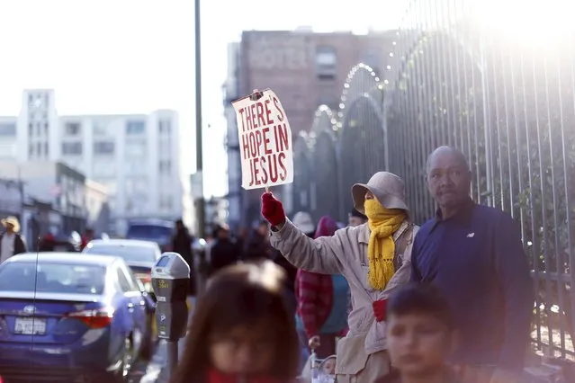 A person holds a sign while waiting in line for an early Thanksgiving meal served to the homeless at the Los Angeles Mission in Los Angeles, California, November 25, 2015. (Photo by Mario Anzuoni/Reuters)