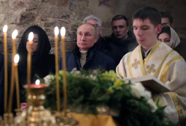 Russian President Vladimir Putin attends the Orthodox Christmas mass at Saint Nikolai Church on Lipno Island in the Msta River delta, outside Veliky Novgorod, on January 7, 2021. Orthodox Christians celebrate Christmas on January 7 in the Middle East, Russia and other Orthodox churches that use the old Julian calendar instead of the 17th-century Gregorian calendar adopted by Catholics, Protestants, Greek Orthodox and commonly used in secular life around the world. (Photo by Mikhail Klimentyev/Sputnik/AFP Photo)