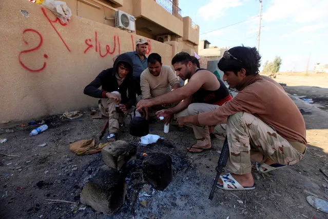 Iraqi army personnel drink tea in Qaraqosh, near Mosul, during an operation to attack Islamic State militants in Mosul, Iraq, November 2, 2016. (Photo by Alaa Al-Marjani/Reuters)