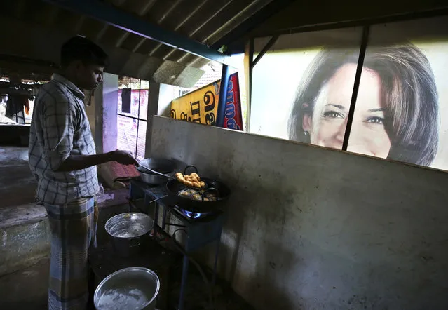 A worker prepares a traditional snack next to a banner featuring U.S. Vice President-elect Kamala Harris, lying outside a local eatery in Thulasendrapuram, the hometown of Harris' maternal grandfather, south of Chennai, Tamil Nadu state, India, Wednesday, January 19, 2021. (Photo by Aijaz Rahi/AP Photo)