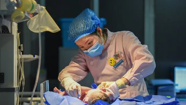 A midwife takes care of a newborn on the Spring Festival eve at the maternity ward of Jingzhou Maternal and Child Health Hospital in Jingzhou, central China's Hubei Province, February 11, 2021. (Photo by CFP/China Stringer Network)