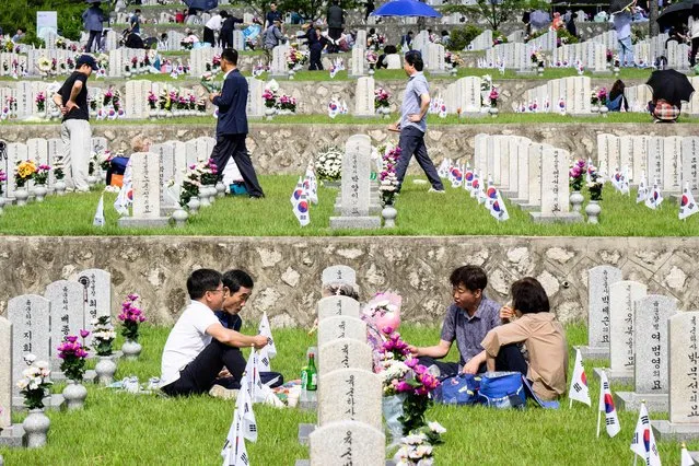 People visit graves at the National Cemetery as South Korea marks Memorial Day, which honours those who died during the 1950-53 Korean War and in other operations while serving their country, in Seoul on June 6, 2023. (Photo by Anthony Wallace/AFP Photo)