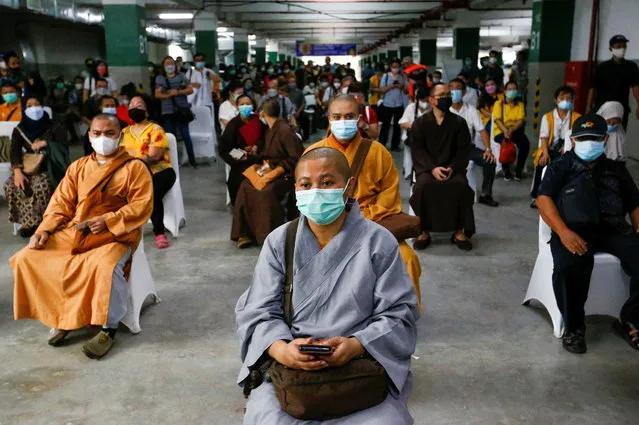 Monks wait to receive their first dose of China's Sinovac Biotech vaccine for the coronavirus disease (COVID-19) at the parking lot of Grand Istiqlal Mosque in Jakarta, Indonesia, February 25, 2021. (Photo by Ajeng Dinar Ulfiana/Reuters)