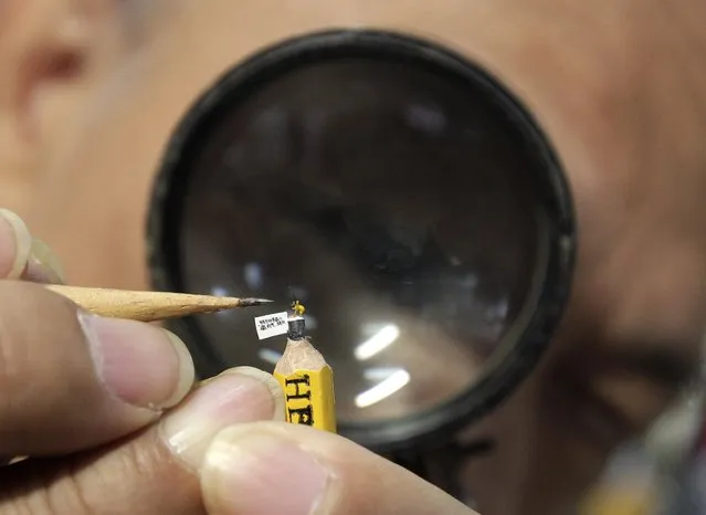 Taiwanese artist Chen Forng-shean looks through a magnifier at his creation, a miniature resin figurine of a Tibetan antelope on top of a pencil, in Taipei January 28, 2015. The Tibetan Antelope is about 0.18 cm (0.07 inches) long and 0.4 cm (0.16 inches) high. Chen created the figurine to welcome the upcoming Lunar Year of the Goat in 2015. (Photo by Pichi Chuang/Reuters)