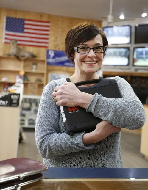 Jessie Palmieri hugs her new H&K VP9 9mm handgun, her first gun, that she bought at the Ringmasters of Utah gun range and store, in Springville, Utah on December 18, 2015. REUTERS/George Frey