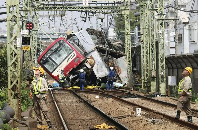 Rescue team work at the crash site, where a train is derailed after a collision with a truck at a crossing in Yokohama, Kanagawa Prefecture on September 5, 2019. (Photo by Kyodo News via Reuters)