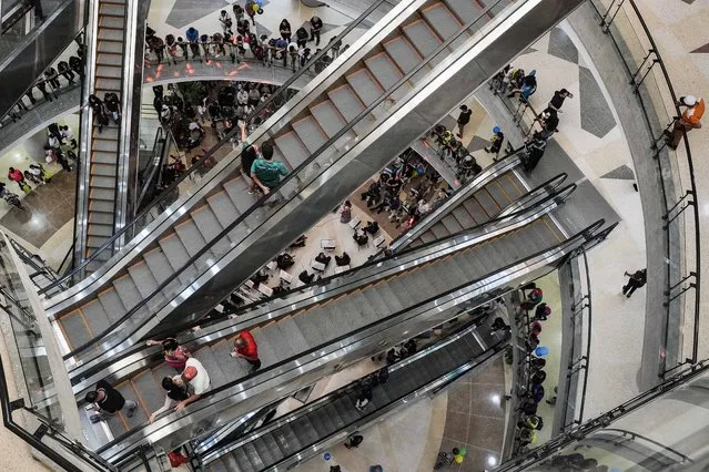 People ride on escalators during the inauguration of the Sambil La Candelaria mall amid soaring and growing inflation, in Caracas, Venezuela, Sunday, May 28, 2023. The mall was expropriated by the Government of late President Hugo Chavez in 2008 and then returned to its owners in 2022 by President Nicolas Maduro. (Photo by Matias Delacroix/AP Photo)