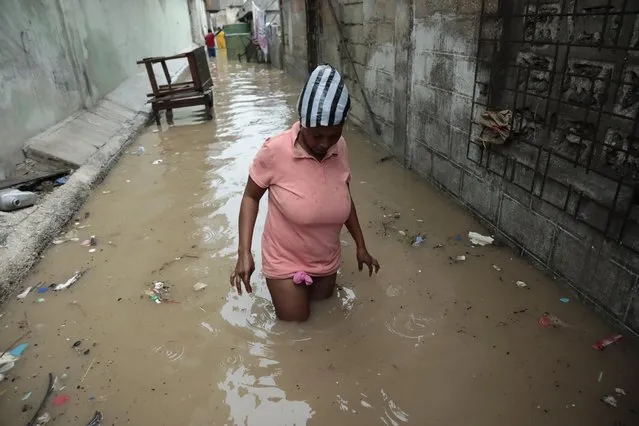 A woman walks through a flooded alleyway, after a heavy rain in Port-au-Prince, Haiti, Saturday, June 3, 2023. (Photo by Joseph Odelyn/AP Photo)