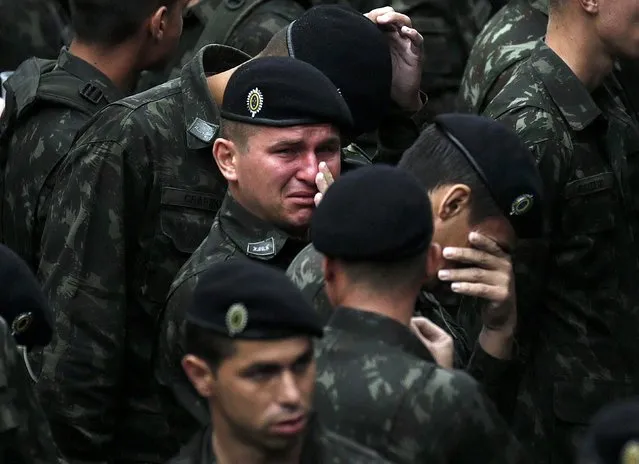 Brazilian soldiers react during a memorial ceremony with the coffins of the victims of the plane crash in Colombia, in the Arena Conda stadium in Chapeco, Brazil, December 3, 2016. (Photo by Ricardo Moraes/Reuters)