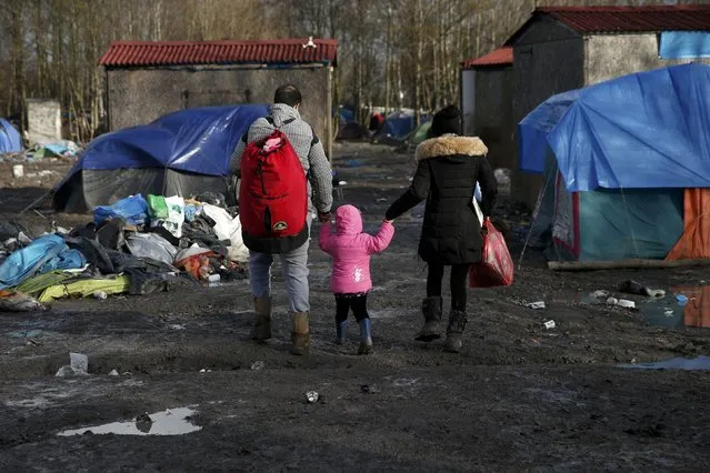 Migrants walks past shelters in a muddy field called the Grande-Synthe jungle, near Dunkirk, northern France, January 12, 2016. The Grande-Synthe jungle is a camp of tents and makeshift shelters where migrants and asylum seekers from Irak, Kurdistan and Syria gather. (Photo by Benoit Tessier/Reuters)