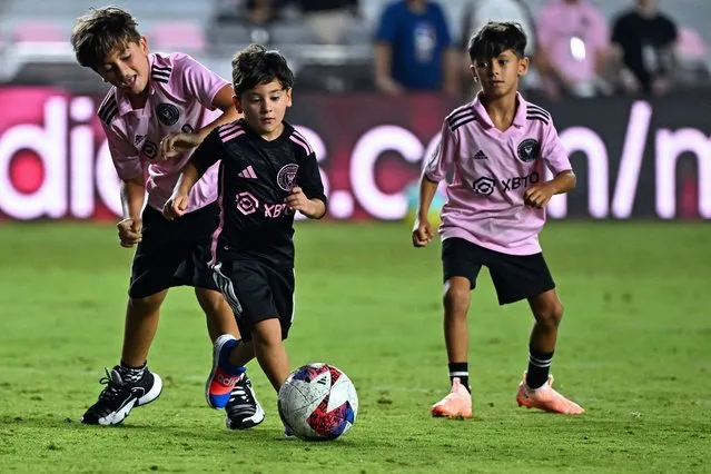 Inter Miami's Argentine forward Lionel Messi's children (L and C) play with a ball after the round of 32 Leagues Cup football match between Inter Miami CF and Orlando City SC at DRV PNK Stadium in Fort Lauderdale, Florida, on August 2, 2023. (Photo by Chandan Khanna/AFP Photo)