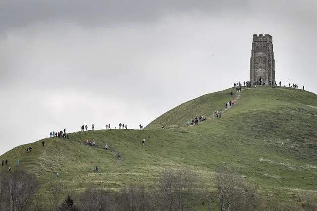 Tourists make the trek up to St Michael's Tower on the top of Glastonbury Tor, in Somerset, southern England, Sunday April 1, 2018.  Forecasters have warned of treacherous driving conditions for Easter holidaymakers with predictions of snow and torrential rain in some areas. (Photo by Ben Birchall/PA Wire via AP Photo)