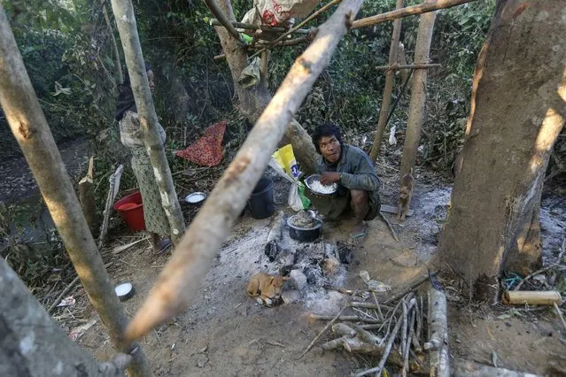 A man eats a meal under his tree house, which acts as a shelter from wild elephants, in Gwe Cho village, Shwe Taung Yan township Ayeyarwady division January 18, 2016. (Photo by Soe Zeya Tun/Reuters)