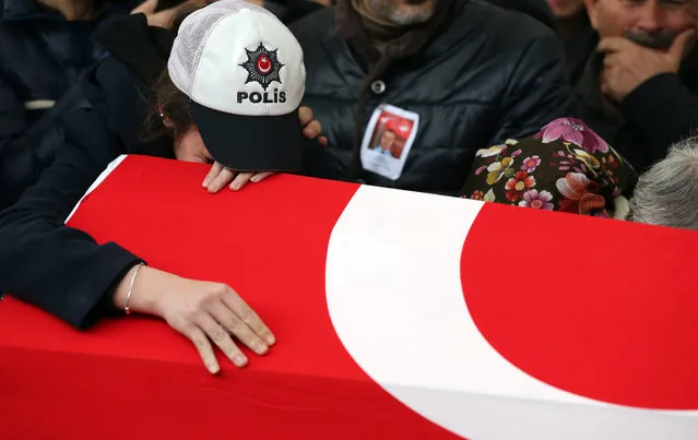 Relatives of police officer Hasim Usta who was killed in bomb attacks outside  the Vodafone Stadium in Besiktas on 10th of December mourn over his coffin during the funeral in Istanbul, Turkey, 12 December 2016. At least 44 people were killed and 160 other wounded in two explosions outside Besiktas Stadium and in nearby Macka Park a few hours after the night's soccer match on 10 December. The bombs apparently targeted police officers who were securing the match. (Photo by Tolga Bozoglu/EPA)