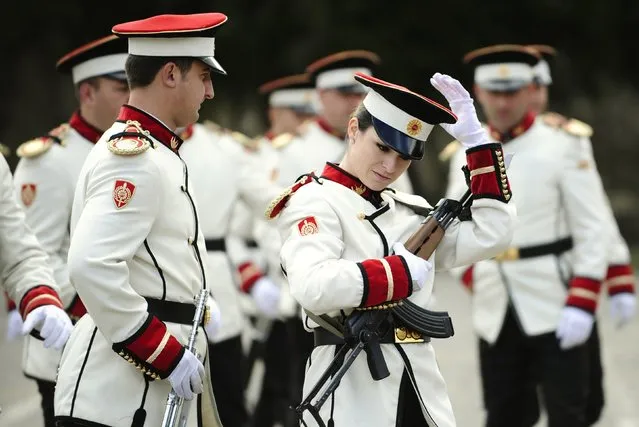 Corporal Dragana Kitanovska adjusts her hat during an honour guard training session at an army barracks in Skopje March 4, 2015.Macedonia's honour army battalion, the ceremonial uniformed guard that receives every foreign president, dignitaries and delegations, but also sees off and welcomes the head of state every time he leaves the country, has a different glow. For the first time in the history of Macedonia's army, the honour guard has two women in its ranks. There has not been an event in which one of them is not in the first row. Verica Zlatevska joined the army in 2003, Kitanovska in 2006. Picture taken March 4, 2015.  REUTERS/Ognen Teofilovski (MACEDONIA  - Tags: MILITARY SOCIETY)