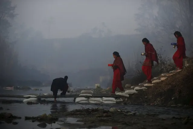 Devotees cross the River Saali in Sankhu during the Swasthani Brata Katha festival in Kathmandu, Nepal, January 24, 2016. (Photo by Navesh Chitrakar/Reuters)