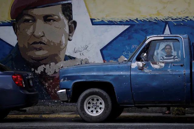 A woman looks on beside a mural depicting former Venezuela's late President Hugo Chavez in Caracas, Venezuela December 2, 2016. (Photo by Ueslei Marcelino/Reuters)
