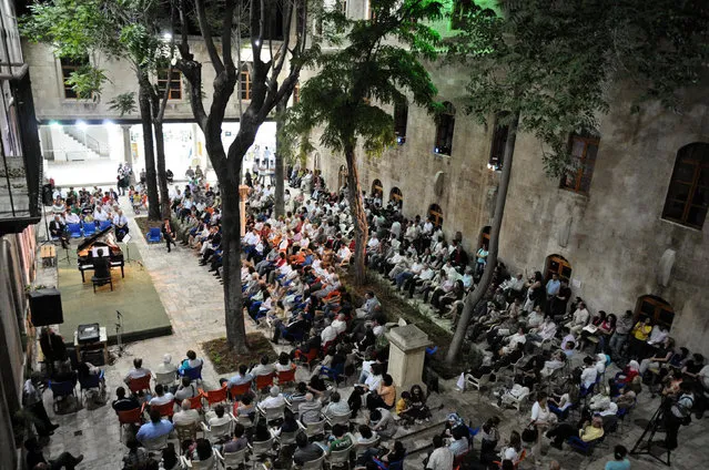 People attend a music concert in al-Sheebani school's courtyard, in the Old City of Aleppo, Syria June 6, 2009. (Photo by Omar Sanadiki/Reuters)