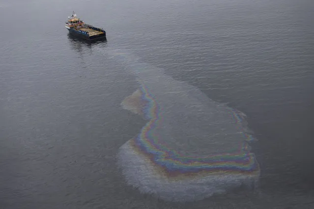 This aerial view shows a boat dumping oil in the waters of Guanabara Bay in Rio de Janeiro, Brazil, Monday, March 23, 2015. Rio de Janeiro's mayor said in a television interview Monday that authorities “should have been able to achieve the goal” of cleaning up Guanabara Bay, where the Olympic sailing events are to be held. He added, “It is indeed a wasted opportunity”. (Photo by Felipe Dana/AP Photo)