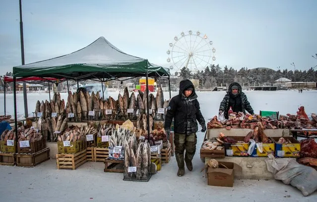 Vendors sell fish and meat products at a farmers' market in the eastern Siberian city of Yakutsk, Russia with the air temperature at about minus 35 degrees Celsius, on November 26, 2018. (Photo by Mladen Antonov/AFP Photo)