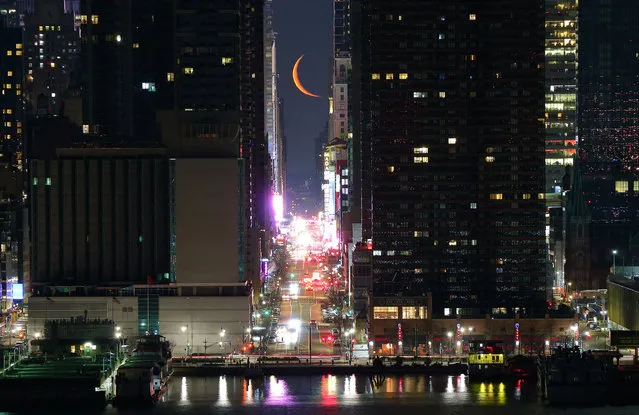A crescent moon rises over 42nd Street in the pre-dawn sky in New York City on March 10, 2021 as seen from Weehawken, New Jersey. (Photo by Gary Hershorn/Getty Images)