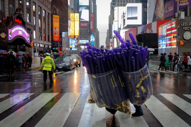 A worker carries balloons to a storage pod ahead of New Year's celebrations in Times Square Manhattan, New York City, U.S., December 29, 2016. (Photo by Andrew Kelly/Reuters)