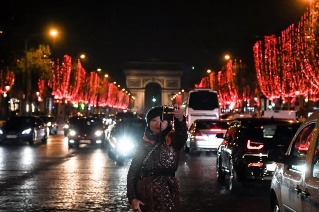 A person takes selfies on the Champs Elysees avenue, in Paris, on November 22, 2018, after the launching of the Champs Elysees Christmas lights. (Photo by Alain Jocard/AFP Photo)