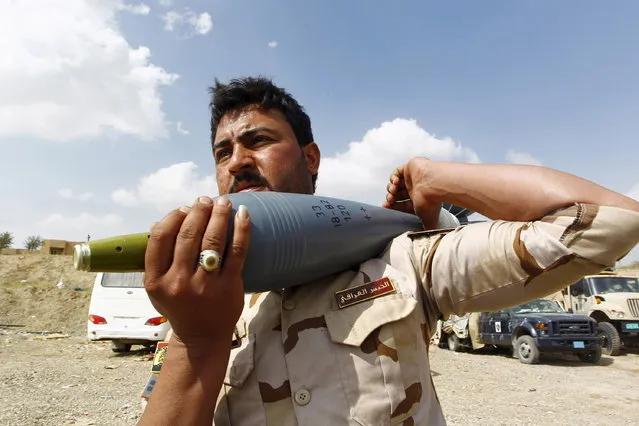 A member of the Iraqi army carry a rocket as he prepares to launch towards Islamic State militants in Tikrit, March 30, 2015. (Photo by Alaa Al-Marjani/Reuters)