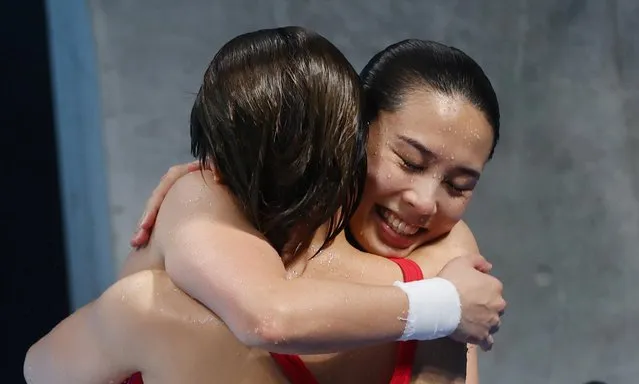 China's Shi Tingmao (L) and China's Wang Han react after they came first to win the gold medal in the women's synchronised 3m springboard diving final event during the Tokyo 2020 Olympic Games at the Tokyo Aquatics Centre in Tokyo on July 25, 2021. (Photo by Kai Pfaffenbach/Reuters)