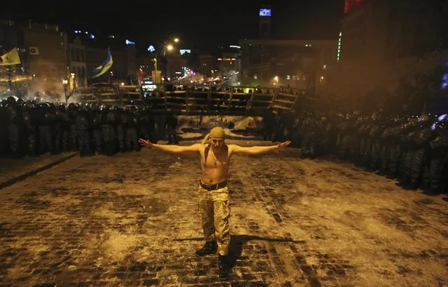 A pro-European integration protester walks between riot police line in Kiev, on December 10, 2013. (Photo by Maxim Zmeyev/Reuters)