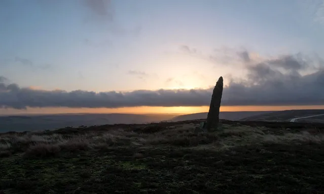 An ancient standing stone is silhouetted as the morning sun rises over the hills and valleys of the North Yorkshire moors on December 20, 2013 near Castleton, United Kingdom. (Photo by Ian Forsyth/Getty Images)