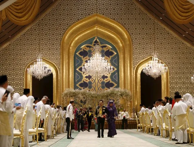 Brunei's newly wed royal couple, Prince Abdul Malik and Dayangku Raabi'atul 'Adawiyyah Pengiran Haji Bolkiah, leave the royal wedding banquet at the Nurul Iman Palace in Bandar Seri Begawan April 12, 2015. (Photo by Olivia Harris/Reuters)