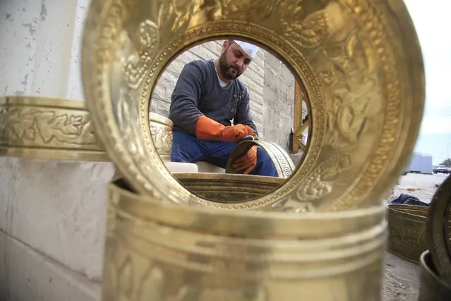 A man polishes brass pots in Sidon, Lebanon February 19, 2016. (Photo by Ali Hashisho/Reuters)