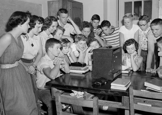 A group of students at the Russell High School in Atlanta, Ga., gather around a radio shortly after noon to hear news that segregation has been ruled out in public schools in a unanimous Supreme Court decision on May 17, 1954. (Photo by Horace Cort/AP Photo)
