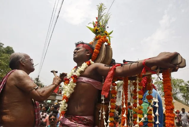 A Hindu devotee reacts as he is nailed to a cross during the annual Shiva Gajan religious festival in Batanal village, east of Kolkata, April 14, 2015. (Photo by Rupak De Chowdhuri/Reuters)