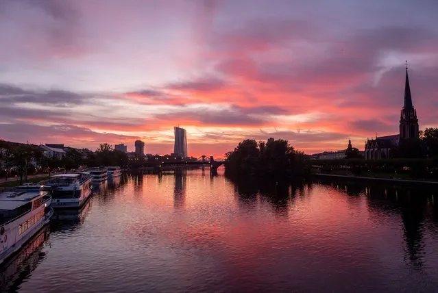 Clouds drift over the river Main in Frankfurt, Germany, before sunrise on Tuesday, October 3, 2023. (Photo by Michael Probst/AP Photo)
